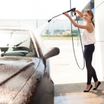 Young woman washing the car